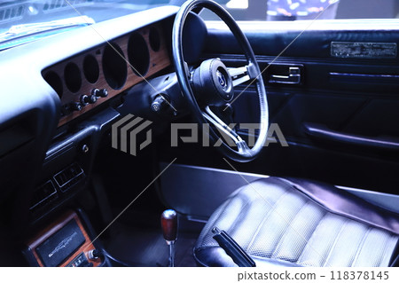 The driver's seat of a Showa-era sports car: Shiny black leather steering wheel and seat 118378145