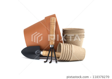 Gardening tools with terracotta pot, biodegradable pots, and spool of twine on a white background 118378270