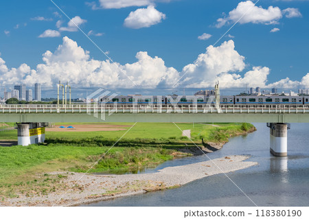 <Tokyo> Odakyu Line running in summer on the Tama River riverbank 118380190