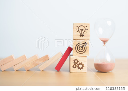 wood block falling to business icon with hour glass or sandglass. brainstorming, Target, goal, teamwork and strategy. risk management, financial, deflation and Inflation and economic recession wood block falling to business icon with hour glass or sandglass. brainstorming, Target, goal, teamwork and strategy. risk management, financial, deflation and Inflation and economic recession 118382135