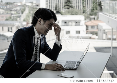 Young Asian businessman working at a desk (worries, troubles, stress, shock, mistakes) 118382742