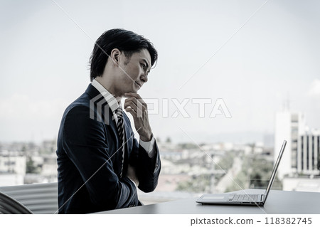 Businessman doing desk work in the office (worrying, thinking, analyzing) 118382745