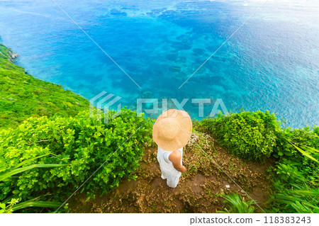 一位在沖繩度假村旅行的女士，面無表情地看著大海 118383243