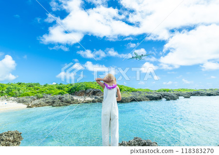 Portrait of a woman looking up at a passenger plane landing at an airport Portrait of a woman looking up at a passenger plane landing at an airport 118383270
