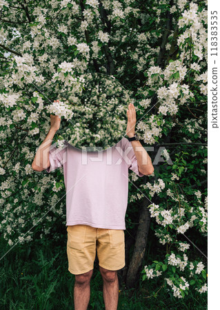 Creative male portrait with mirror in blooming apples spring garden Creative male portrait with mirror in blooming apples spring garden 118383535