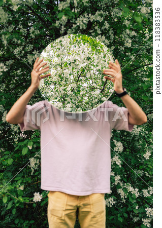 Creative male portrait with mirror in blooming apples spring garden Creative male portrait with mirror in blooming apples spring garden 118383536