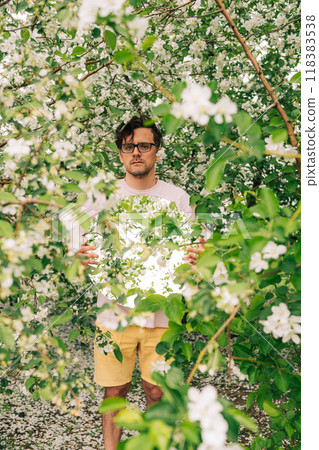 Creative male portrait with mirror in blooming apples spring garden 118383538