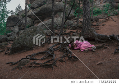 Woman in the taiga forest and rocks of the Stolby nature reserve park 118383555