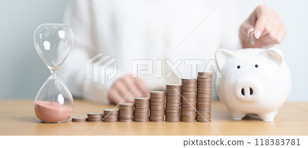 Money Saving for Future Plan, Retirement fund, Pension, Investment, Wealth Business and Financial concepts. coins stack, piggy bank with sandglass on table Money Saving for Future Plan, Retirement fund, Pension, Investment, Wealth Business and Financial concepts. coins stack, piggy bank with sandglass on table 118383781