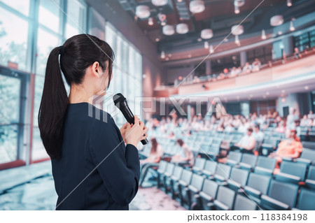 A young woman hosting a meeting in a hall A young woman hosting a meeting in a hall 118384198
