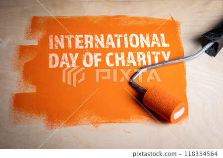 International Day of Charity, 5 September. Orange color on wood texture background 118384564