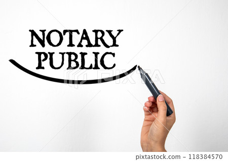 NOTARY PUBLIC. Hand holding black marker and writing on white background NOTARY PUBLIC. Hand holding black marker and writing on white background 118384570