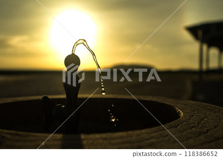 A drinking fountain in the sunset 118386652