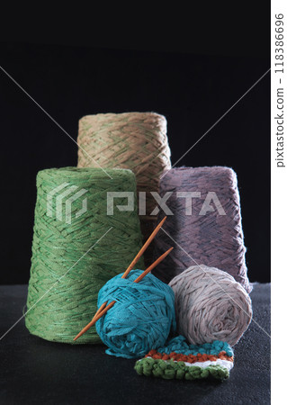 Multicolored yarn for knitting in bobbins. Textured yarn for handmade. Knitting needles made of bamboo. A sample is linked. The concept of a hobby. Vertical photo. Handiwork. Multicolored yarn for knitting in bobbins. Textured yarn for handmade. Knitting needles made of bamboo. A sample is linked. The concept of a hobby. Vertical photo. Handiwork. 118386696