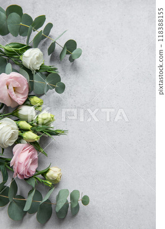 Delicate arrangement of mixed flowers and eucalyptus leaves on a light grey surface Delicate arrangement of mixed flowers and eucalyptus leaves on a light grey surface 118388155