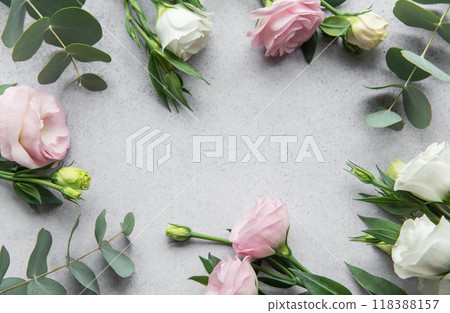 Delicate arrangement of mixed  flowers and eucalyptus leaves on a light grey surface 118388157