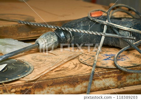 Electric hammer drill on metal surface with drills. Construction 118389203