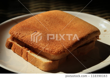 Toast bread on a white plate in the morning sun light. 118390163