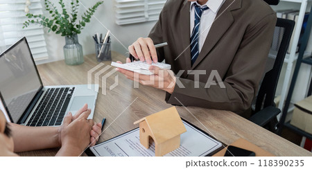 Real Estate Agent Assessing Loan Options with Client for Optimal Property Investment Real Estate Agent Assessing Loan Options with Client for Optimal Property Investment 118390235