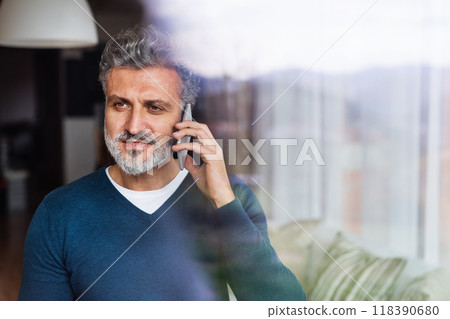 Portrait of handsome man making phone call, looking at camera and smiling. 118390680