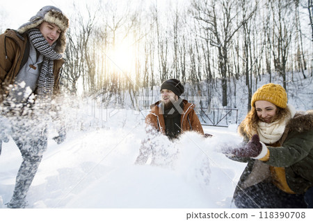 Friends in snowball fight in snowy nature having fun. First snowfall of the season. 118390708