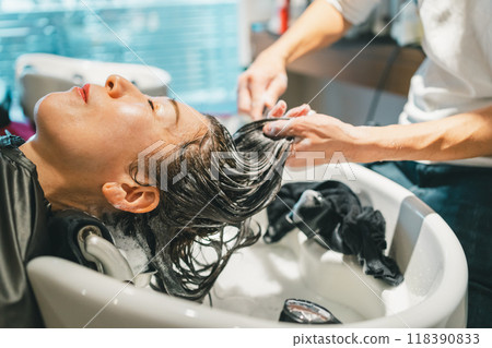 Adult woman shampooing at a beauty salon Adult woman shampooing at a beauty salon 118390833