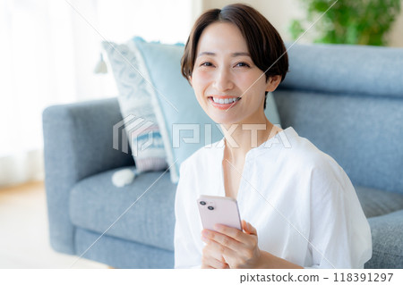 中間女人在房間裡操作智能手機 118391297
