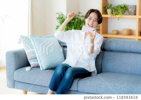 Middle woman operating a smartphone in the room Middle woman operating a smartphone in the room 118391618