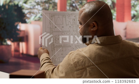 Business owner using digital tools to review and evaluate office spaces blueprints, focusing on leasing a functional and creative workspace. Searches for real estate, strategy planning. Camera A. 118392683