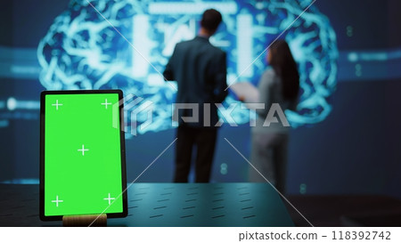 Green screen tablet used by computer scientists in startup doing advancements in AI field. Employees working on mockup device in workspace featuring artificial intelligence systems, camera B Green screen tablet used by computer scientists in startup doing advancements in AI field. Employees working on mockup device in workspace featuring artificial intelligence systems, camera B 118392742