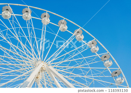 Ferris wheel structure against clear blue sky, sunny day, city park 118393130