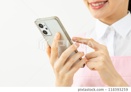 Woman in an apron operating a smartphone 01 118393259