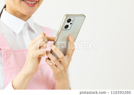 穿著圍裙的女人操作智慧型手機 02 穿著圍裙的女人操作智慧型手機 02 118393260