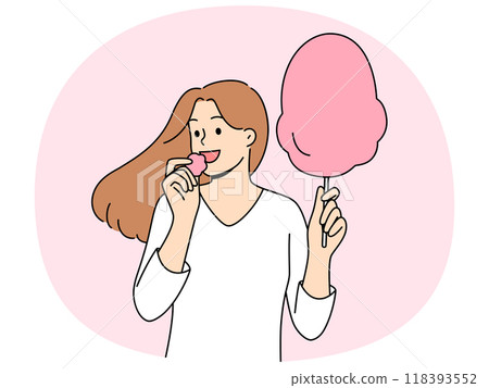 Woman eats cotton candy, enjoying airy sugar dessert while walking in park or at fair Woman eats cotton candy, enjoying airy sugar dessert while walking in park or at fair 118393552
