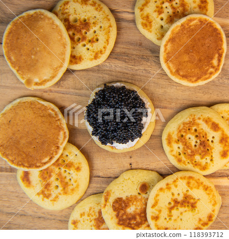 Blinis with black caviar and cream cheese, on a festive dish, mini pancakes, an elegant appetizer Blinis with black caviar and cream cheese, on a festive dish, mini pancakes, an elegant appetizer 118393712