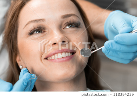 Thanks to the attentive approach of the dentist, the patient sits in the dental chair, demonstrating her trust and satisfaction. The procedure was confident and painless, giving the patient a sense of Thanks to the attentive approach of the dentist, the patient sits in the dental chair, demonstrating her trust and satisfaction. The procedure was confident and painless, giving the patient a sense of 118394239