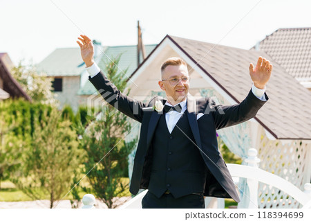 Joyful Groom Celebrating Outdoors in Elegant Tuxedo at Charming Rustic Venue 118394699