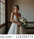 Bride in a wedding dress smiling with a bouquet in her hand 118394774