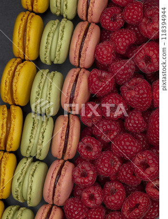 macaroons of different colors with raspberries 118394944