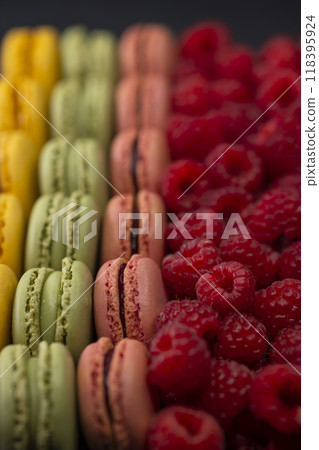 macaroons of different colors with raspberries 118395924