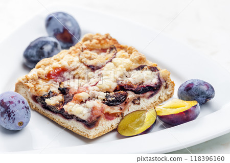 piece of plum pie with plums around 118396160