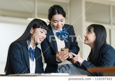 A high school girl looking at her smartphone in a classroom 118397481