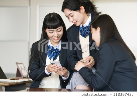 A high school girl looking at her smartphone in a classroom A high school girl looking at her smartphone in a classroom 118397483