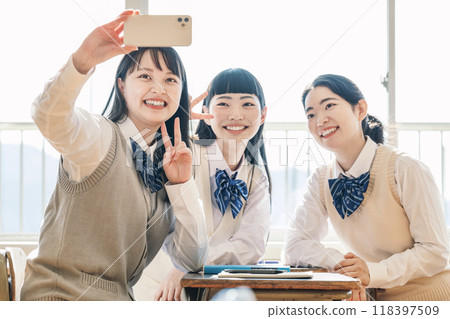 High school girls taking photos with their friends High school girls taking photos with their friends 118397509
