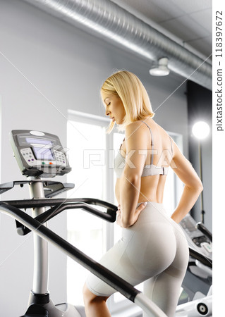 Young woman in sportswear working out at the gym. She is working out on stairway simulator 118397672