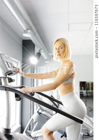 Young woman in sportswear working out at the gym. She is working out on stairway simulator 118397673