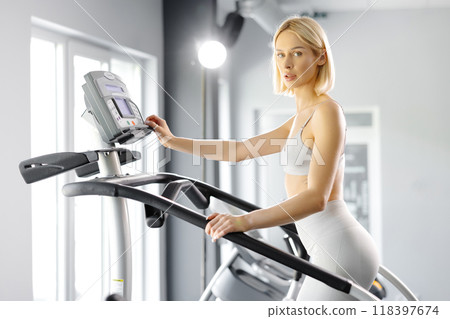 Young woman in sportswear working out at the gym. She is working out on stairway simulator 118397674