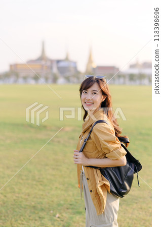A Traveler Asian woman in her 30s exploring Wat Pra Kaew. From stunning architecture to friendly locals, she cherishes every moment, capturing it all in her heart and camera for years to come. 118398696
