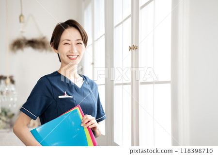 Middle-aged female staff member holding a binder 118398710
