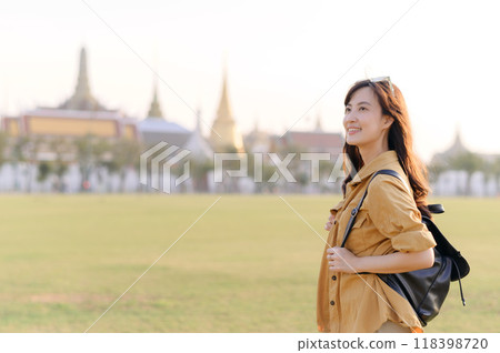 A Traveler Asian woman in her 30s exploring Wat Pra Kaew. From stunning architecture to friendly locals, she cherishes every moment, capturing it all in her heart and camera for years to come. 118398720